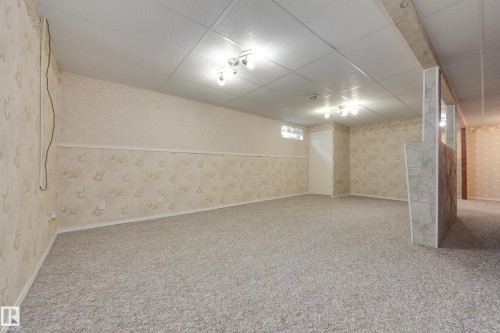 Spacious interior with neutral carpet flooring and patterned wallpaper - 3421 135A Avenue Nw, Edmonton, AB 