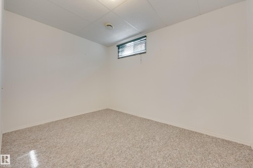 Recessed window with horizontal blinds, neutral wall paint, and textured carpet flooring - 3421 135A Avenue Nw, Edmonton, AB 