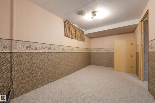 Carpeted flooring, acoustic tile ceiling, and bi-fold doors - 3421 135A Avenue Nw, Edmonton, AB 