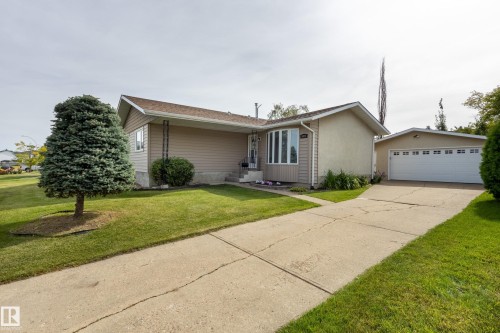Split-level residence featuring light-toned siding, a detached garage, and a concrete driveway - 3421 135A Avenue Nw, Edmonton, AB 
