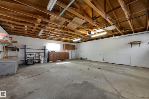 Exposed wood ceiling beams, concrete flooring, built-in lower cabinetry, and wall-mounted shelving - 3421 135A Avenue Nw, Edmonton, AB 