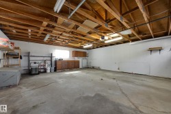 Exposed wood ceiling beams, concrete flooring, built-in lower cabinetry, and wall-mounted shelving - 