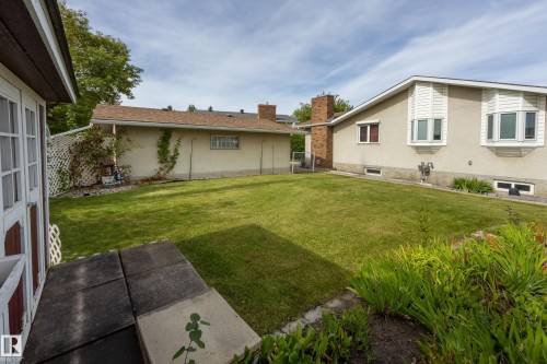 Expansive green lawn with mature landscaping and a brick chimney - 3421 135A Avenue Nw, Edmonton, AB 
