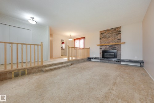 Brick fireplace with wood mantle and black hearth - 3421 135A Avenue Nw, Edmonton, AB 