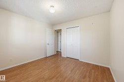 Wood-finish flooring with neutral wall tones and a white ceiling - 