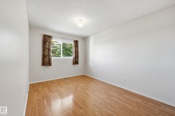 Light wood-finish flooring, white walls, and a window with a natural outdoor backdrop - 