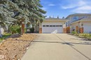 Light-colored siding exterior with brick accents, an attached two-car garage, and mature landscaping - 11102 11A Avenue Nw, Edmonton, AB 