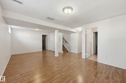 Expansive finished room featuring wood-finish flooring, recessed lighting, and a neutral color palette - 