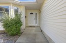 Entrance featuring a paneled door with a decorative window, a side light, and an exterior wall light - 11102 11A Avenue Nw, Edmonton, AB 