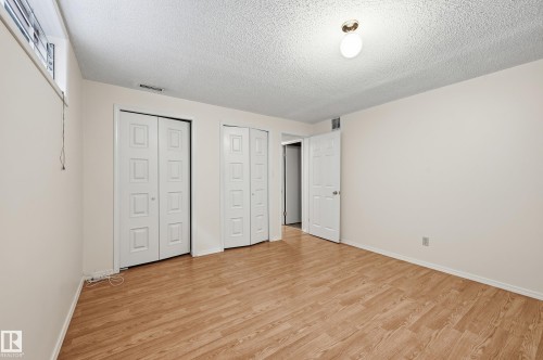 Wood-finish flooring throughout, two bi-fold panel doors, and a single pane window - 11102 11A Avenue Nw, Edmonton, AB 