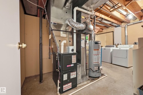 Basement utility area featuring a water heater, furnace, and exposed ceiling joists - 11102 11A Avenue Nw, Edmonton, AB 