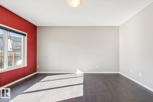 Wood-finish flooring, white trim, and a window with a roller shade - 12007 173 Avenue Nw, Edmonton, AB 