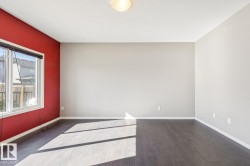 Wood-finish flooring, white trim, and a window with a roller shade - 