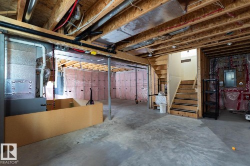 Unfinished basement with exposed wood joists, concrete flooring, and a visible furnace unit - 12007 173 Avenue Nw, Edmonton, AB 