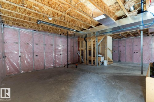 Unfinished basement with exposed ceiling joists, concrete flooring, and insulated perimeter walls - 12007 173 Avenue Nw, Edmonton, AB 
