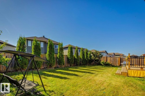 Expansive backyard with a manicured lawn, established privacy trees, and a wooden fence - 12007 173 Avenue Nw, Edmonton, AB 