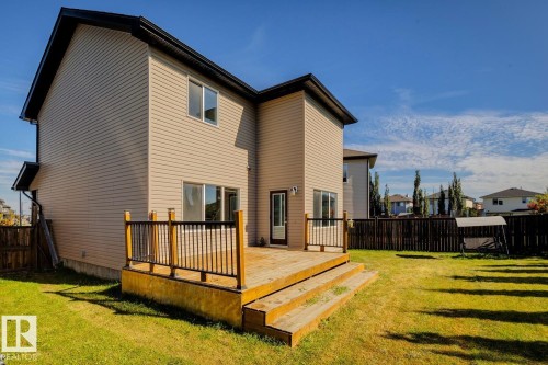 Rear exterior with a wood deck, sliding glass door, and a fenced yard - 12007 173 Avenue Nw, Edmonton, AB 