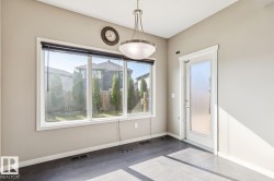 Expansive window featuring a backyard, wood-finish flooring, and a pendant light fixture - 