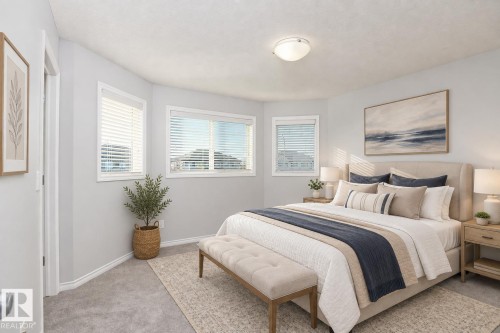 Recessed ceiling light, two windows with blinds, light gray wall paint, light gray carpeting, and an upholstered bed frame - 441 Songhurst Place, Leduc, AB 