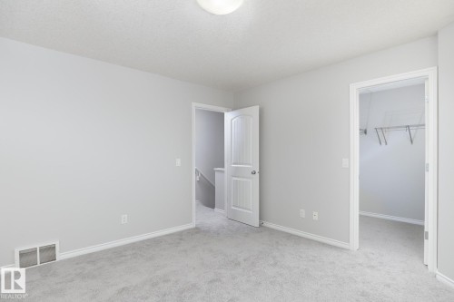Light gray carpeting, white trim, and a flush-mount ceiling light - 441 Songhurst Place, Leduc, AB 