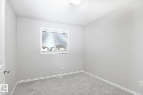 Light gray carpeting with matching baseboards and light gray walls - 441 Songhurst Place, Leduc, AB 