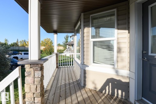 Covered front porch featuring wood-finish flooring - 441 Songhurst Place, Leduc, AB 