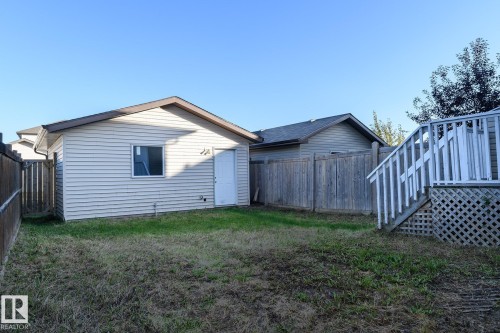 Detached outbuilding with vinyl siding, a single window, and a white entry door - 441 Songhurst Place, Leduc, AB 