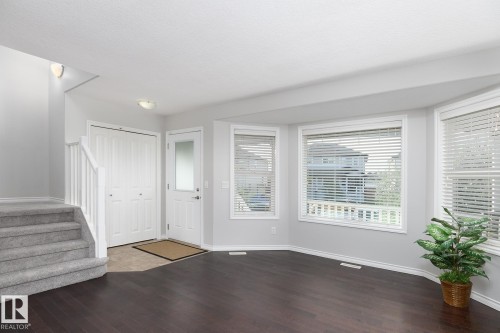 Dark wood-finish flooring with a multi-pane bay window - 441 Songhurst Place, Leduc, AB 