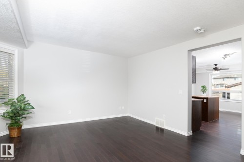 Dark wood-finish flooring, white walls, and a recessed window - 441 Songhurst Place, Leduc, AB 