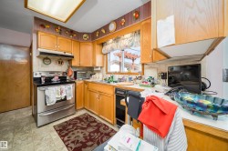 Kitchen featuring wood-finish cabinetry, a stainless steel range, and a built-in dishwasher - 