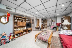 Recessed lighting, wood-finish built-in shelving, suspended ceiling system, and light-toned carpeting - 