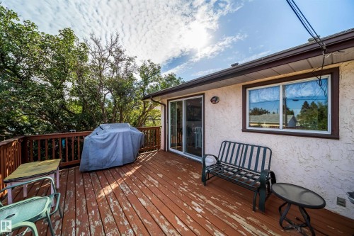 Expansive wood deck with a full-height railing, sliding glass door, and a horizontal sliding window - 4808 106 Avenue Nw, Edmonton, AB 