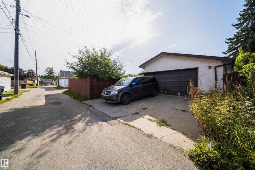Attached garage with a dark panel door and concrete driveway - 4808 106 Avenue Nw, Edmonton, AB 