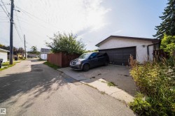 Attached garage with a dark panel door and concrete driveway - 