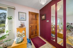 Hardwood paneled entry door with sidelight, tiled flooring, and a crystal ceiling fixture - 