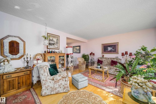 Hardwood flooring, light-toned wall paint, textured ceiling, decorative wall mirror, framed artwork - 4808 106 Avenue Nw, Edmonton, AB 