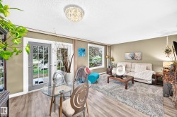 Light-toned walls with wood-finish flooring, featuring a crystal-adorned ceiling light and transom windows - 