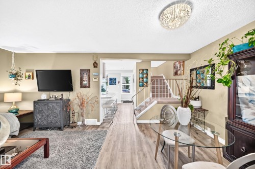 Wood-finish flooring throughout, with a decorative ceiling light fixture - 5620 93A Avenue Nw, Edmonton, AB 