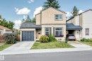 Stucco exterior with a shingled roof, attached garage, and a covered carport - 5620 93A Avenue Nw, Edmonton, AB 