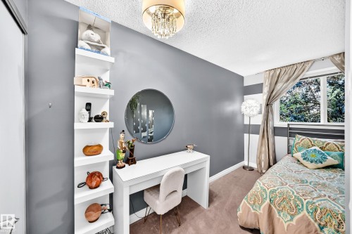 Recessed window with natural light, textured ceiling, wall-mounted shelving, built-in desk, and chandelier lighting fixture - 5620 93A Avenue Nw, Edmonton, AB 