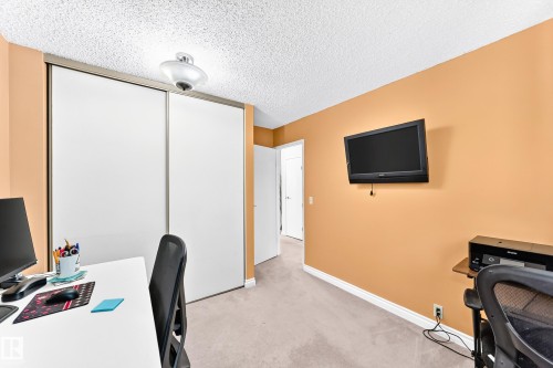 Built-in closet with sliding doors, neutral carpeting, and a ceiling-mounted light fixture - 5620 93A Avenue Nw, Edmonton, AB 