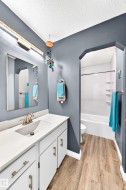White vanity with brushed nickel hardware, integrated sink, and light-colored countertop - 