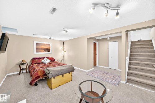 Carpeted flooring, neutral wall tones, track lighting, ceiling-mounted lighting, and a carpeted staircase - 5620 93A Avenue Nw, Edmonton, AB 