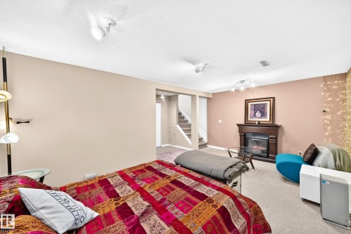 Recessed lighting, wood-finish fireplace surround, carpeting, and staircase - 5620 93A Avenue Nw, Edmonton, AB 