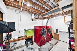 Utility space featuring exposed ceiling joists, white-painted walls, and concrete flooring - 