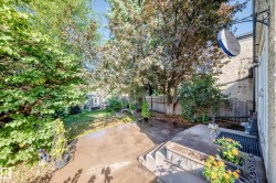 Expansive backyard featuring a concrete patio, mature trees, and privacy fencing - 