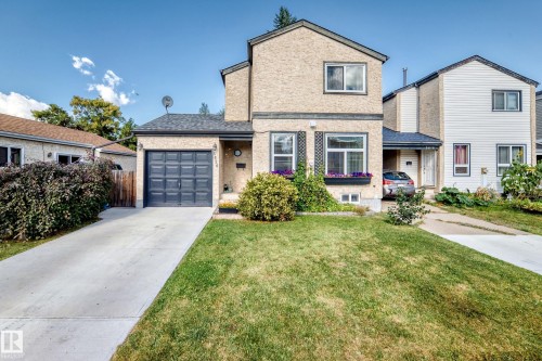 Stucco exterior with a peaked roof, attached garage, and a concrete driveway - 5620 93A Avenue Nw, Edmonton, AB 