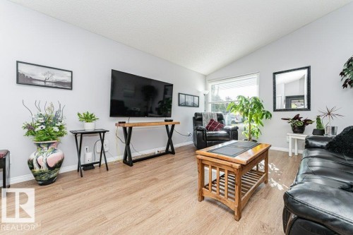 Vaulted ceiling enhancing the spacious feel, wood-finish flooring, and large window providing ample natural light - 6 Kiniski Crescent Nw, Edmonton, AB 