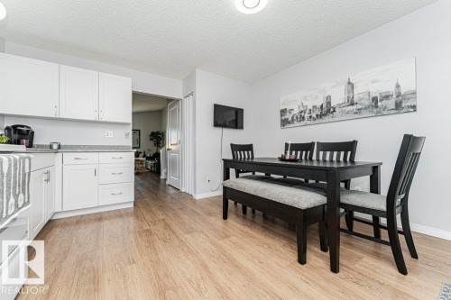 Light-toned wood-finish flooring, white cabinetry with silver-tone hardware, and a light gray countertop - 6 Kiniski Crescent Nw, Edmonton, AB 