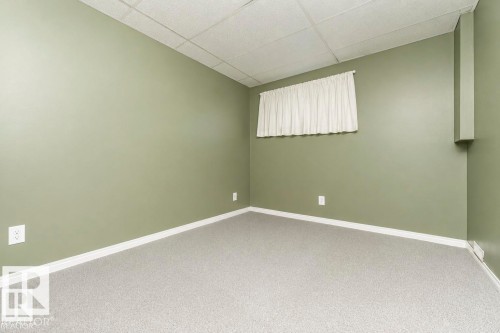 Room featuring neutral green walls, light-colored carpeting, and a drop ceiling - 6 Kiniski Crescent Nw, Edmonton, AB 